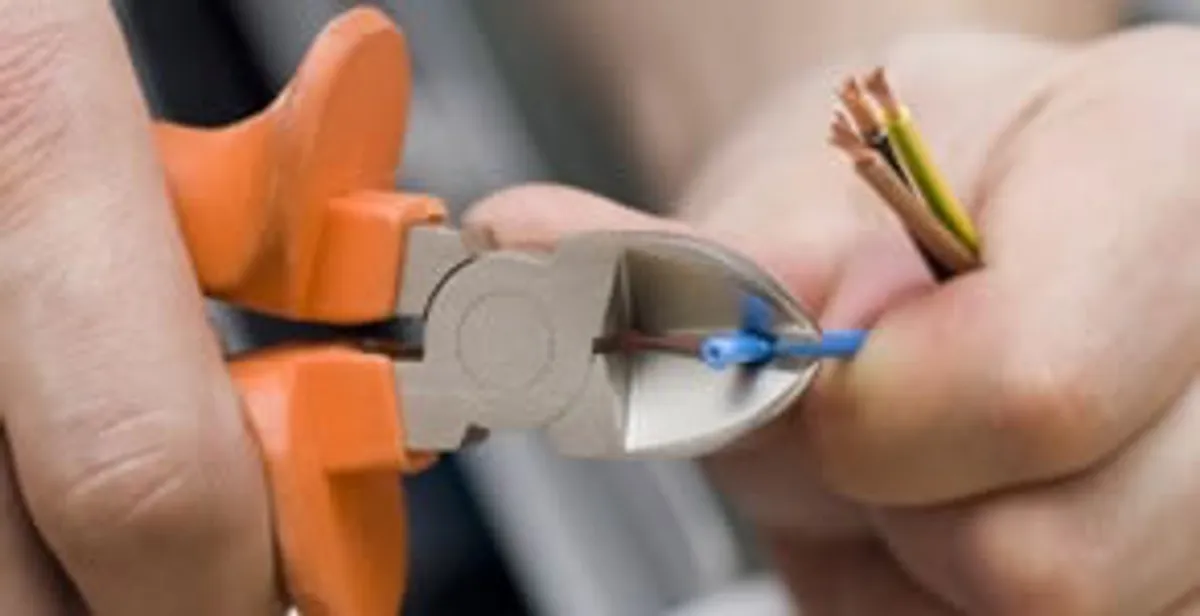 licensed electrician performing precise wire cutting and preparation during electrical service in Reno, NV