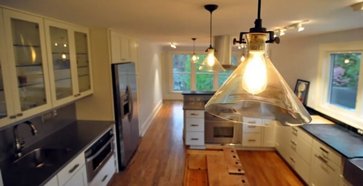 Residential electrician installing modern indoor light fixture in a home in Reno, NV